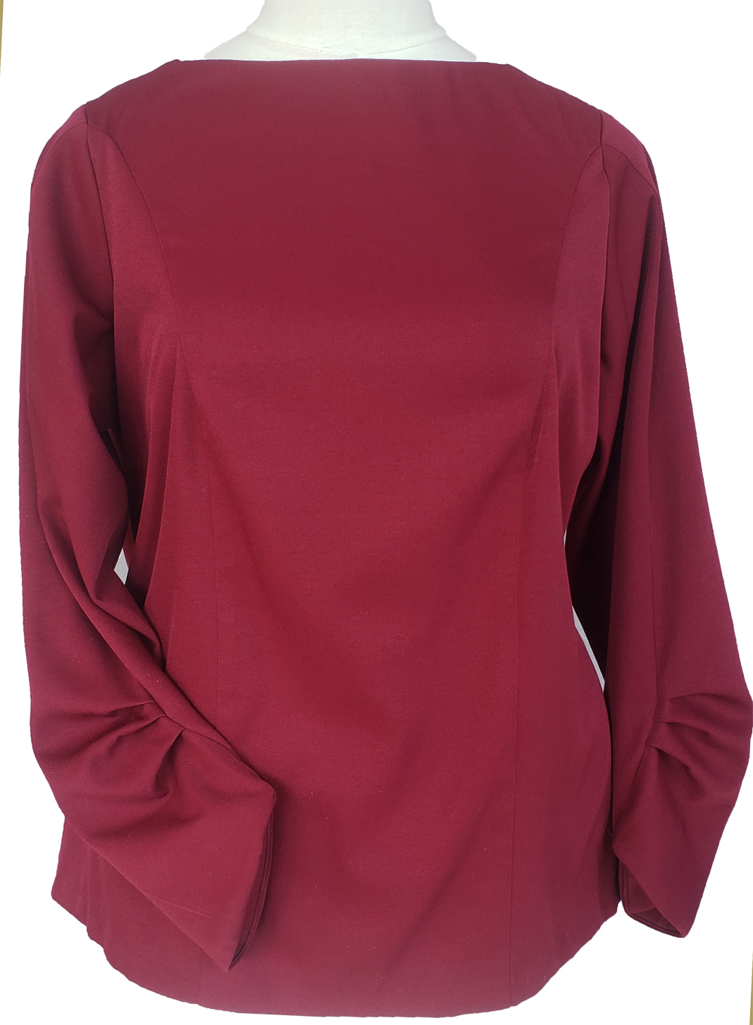 A digital sewing pattern for a long-sleeved shirt.  The garment is made of stretchy burgundy fabric and is on a mannequin
