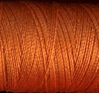 a spool of burnt orange Gütermann Maraflex stretch thread