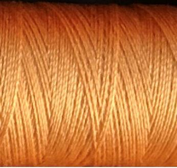a spool of light orange Gütermann Maraflex stretch thread