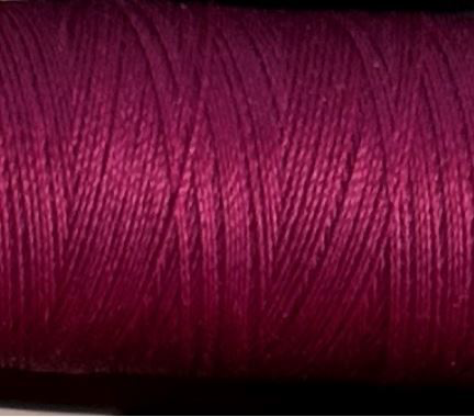 a spool of dark magenta Gütermann Maraflex stretch thread