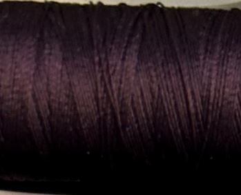 a spool of aubergine Gütermann Maraflex stretch thread