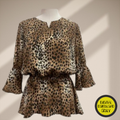 A digital sewing pattern for a long sleeved blouse on a mannequin that is made of cougar print fabric, it is gathered around the waist