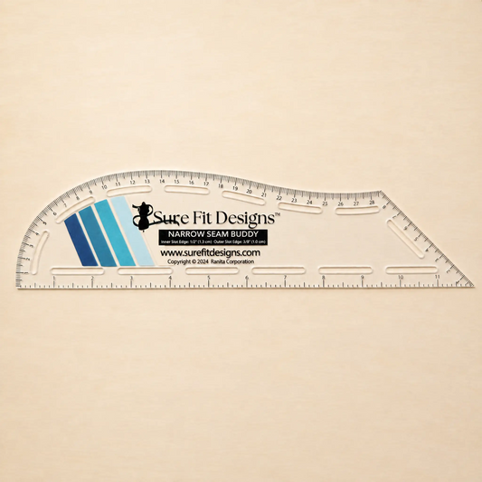A clear plastic sewing and ruler with printed measurement markings and the Sure Fit Designs logo, placed on a light beige textured background.